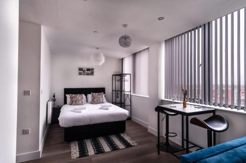 a bedroom with a bed and a desk in it at Modern Studio Apartment near Old Trafford in Manchester