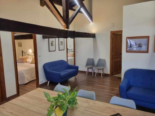 a living room with two blue chairs and a bed at Lanchas de La Vera in Madrigal de la Vera