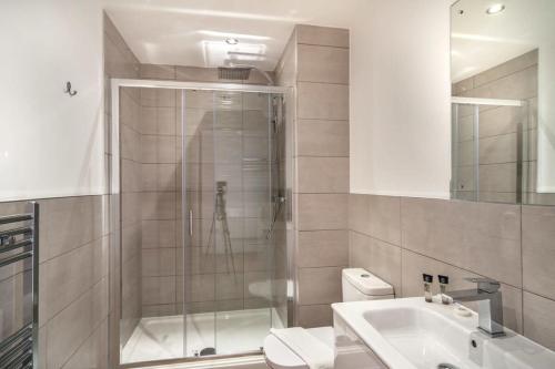a bathroom with a shower and a toilet and a sink at Modern & Spacious 2 Bed Apartment by Old Trafford in Manchester