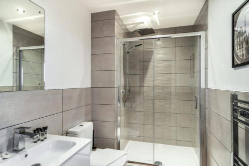 a bathroom with a shower and a toilet and a sink at StayZeni, Alexandra Rise Manchester Super 1 Bed in Manchester