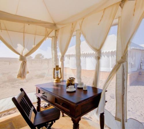Una mesa en una habitación con vistas al desierto en Sam Safari Resort Jaisalmer, en Jaisalmer