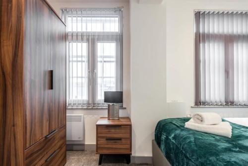 a bedroom with a bed and a television and windows at Fantastic 1 Bed Budget Apartment in Doncaster in Doncaster