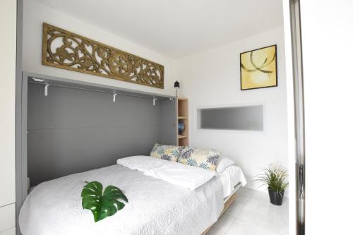 een slaapkamer met een wit bed en een plant bij ArtApartment G 13 in Wisła