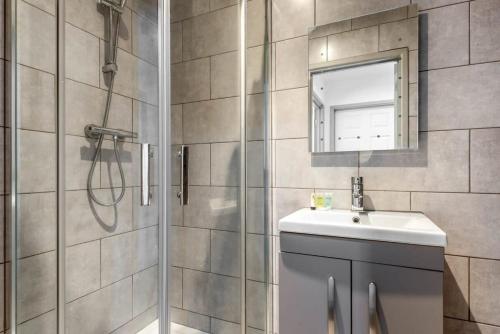 een badkamer met een douche, een wastafel en een spiegel bij Modern 1 Bed Budget Apartment in Central Halifax in Halifax