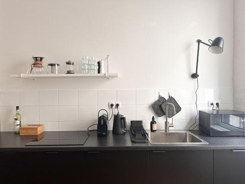 a kitchen with a sink and a counter top at NOOK Design Apartments with Kitchen in Berlin