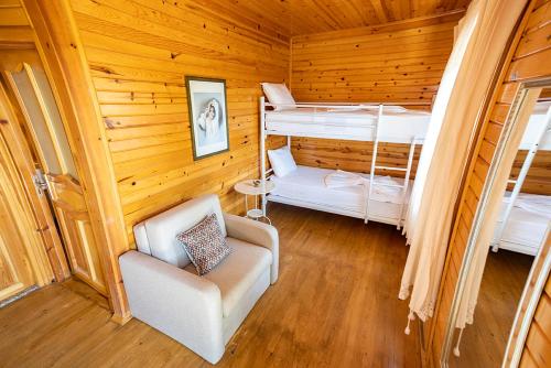 Zimmer mit 2 Etagenbetten und einem Stuhl in der Unterkunft Olbios Marina Resort Hotel in Kumkuyu