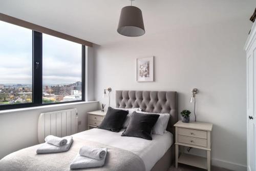 a bedroom with a bed with a large window at Lovely Modern 1 Bed Apartment by Old Trafford in Manchester