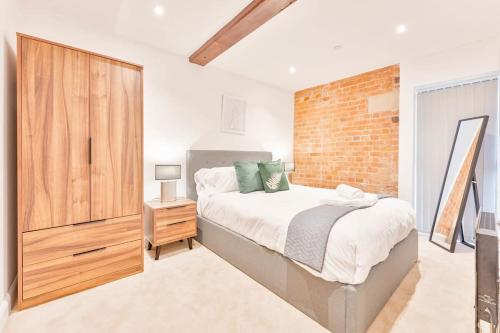 a bedroom with a bed and a brick wall at Lovely 1 Bed Apartment in Burton-on-Trent in Burton upon Trent