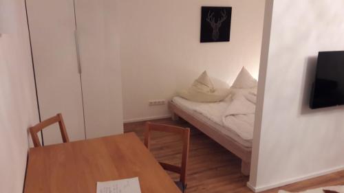 Cette petite chambre comprend un lit et une table. dans l'établissement FeWo Wurmberg Domizil ZZ-BRAUNLAGE, à Braunlage