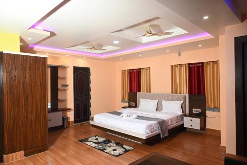 ボルプルにあるTulusi Inn, Bolpur Shantiniketanのベッドルーム(ベッド1台、紫色のライト付)