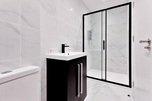 uma casa de banho branca com um lavatório e um chuveiro em Beautiful 1 Bed Apartment in Burton-on-Trent em Burton upon Trent