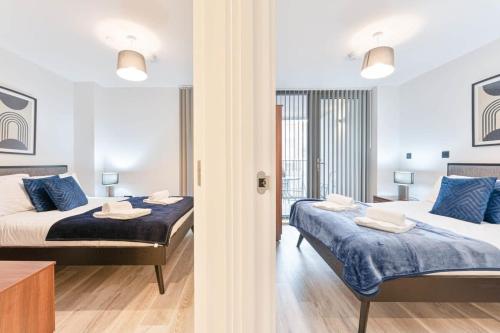 伯明罕的住宿－Lovely Central Birmingham 2 Bed Apartment，一间卧室配有两张带蓝色枕头的床
