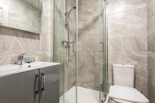 a bathroom with a shower and a toilet and a sink at Modern 1 Bedroom Budget Apartment in Barnsley in Barnsley