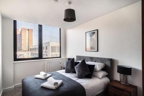 a bedroom with a bed with two towels on it at Modern & Spacious 1 Bed Apartment - Old Trafford in Manchester