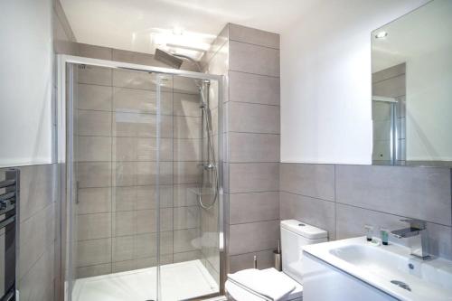 a bathroom with a shower and a toilet and a sink at Modern & Spacious 1 Bed Apartment - Old Trafford in Manchester