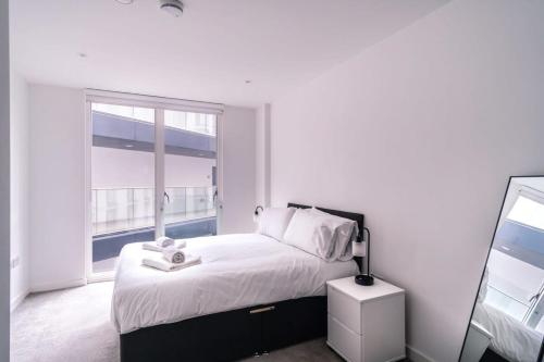 Un dormitorio blanco con una cama grande y una ventana en Spacious 1 Bed Apartment in Central Manchester en Mánchester