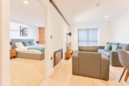 um quarto e uma sala de estar com uma cama e um sofá em Stylish 2 Bed Apartment in Burton-on-Trent em Burton upon Trent