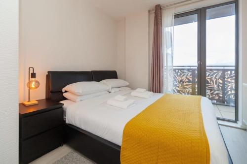 um quarto com uma cama grande e uma janela em Smart 1 Bedroom Apartment in Canning Town em Londres