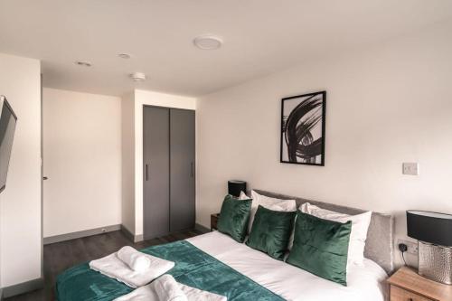 a bedroom with a bed with green and white pillows at Smart 1 Bedroom Apartment in Liverpool Centre in Liverpool