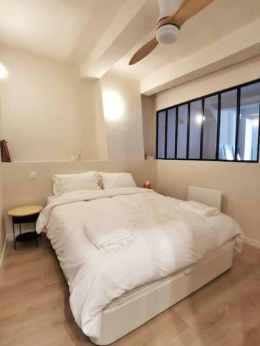 un grand lit blanc dans une chambre avec une fenêtre dans l'établissement Confortable et cosy appartement en centre-ville, à Aix-en-Provence