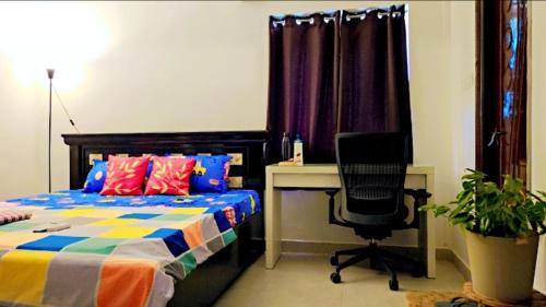 a bedroom with a bed and a desk and a chair at Ruchika's Orchid in Hyderabad