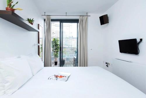 Un dormitorio blanco con una cama blanca y una ventana en Modern 2 Bed Apartment w Balcony in London en Londres