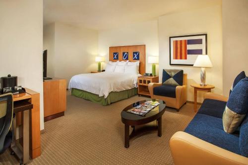 a hotel room with a bed and a couch at Renaissance Walnut Creek Hotel in Walnut Creek