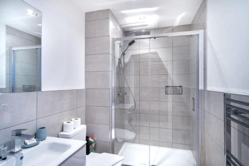 uma casa de banho com um chuveiro, um WC e um lavatório. em Spacious 1 Bed Old Trafford Apartment em Manchester