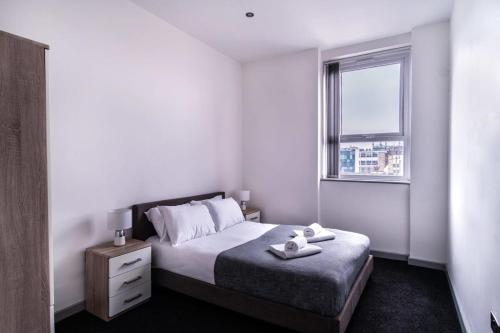 Contemporary 1 Bed Apartment in Central Blackburn في بلاكبيرن: غرفة نوم بيضاء بها سرير ونافذة