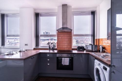 a kitchen with a sink and a stove at Contemporary 1 Bed Apartment in Central Blackburn in Blackburn