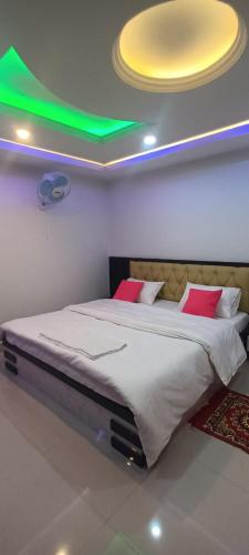 - une chambre avec un grand lit et un plafond vert dans l'établissement Hotel Raxaul King, à Raxaul