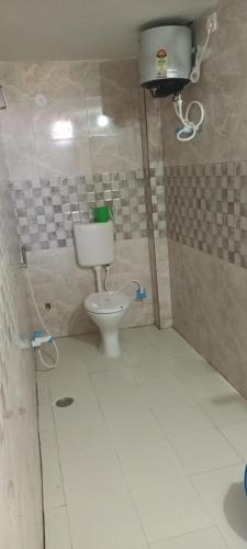 a bathroom with a toilet in a tiled room at Hotel Raxaul King in Raxaul