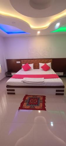 a bedroom with a large bed with red pillows at Hotel Raxaul King in Raxaul