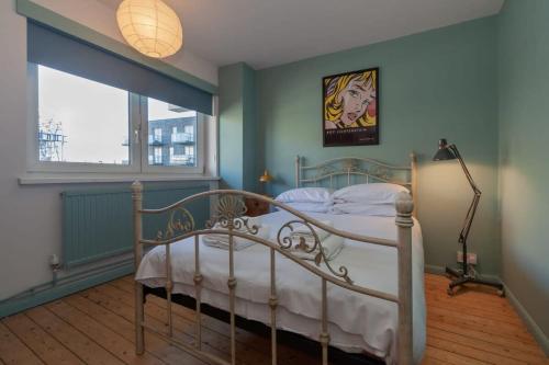 um quarto com uma cama branca num quarto com uma janela em Centrally Located 4 Bedroom London Apartment em Londres