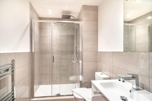 a bathroom with a shower and a sink and a toilet at StayZeni, Alexandra Rise Manchester 2 Bed Flat in Manchester