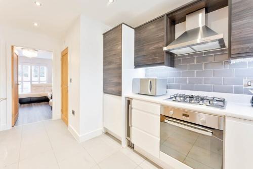 a kitchen with white cabinets and a stove top oven at Modern 2 Bedroom House in Wolverhampton in Wolverhampton