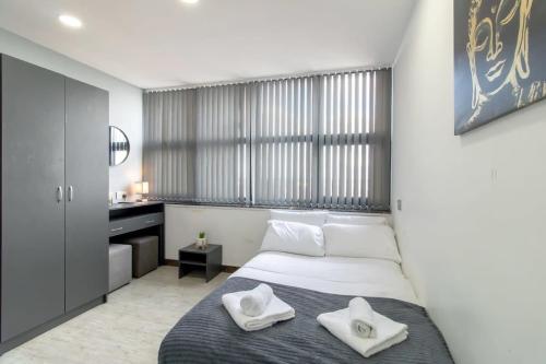 1 dormitorio con 1 cama y 2 toallas blancas en Smart Budget Sunderland Studio with Great Views, en Sunderland