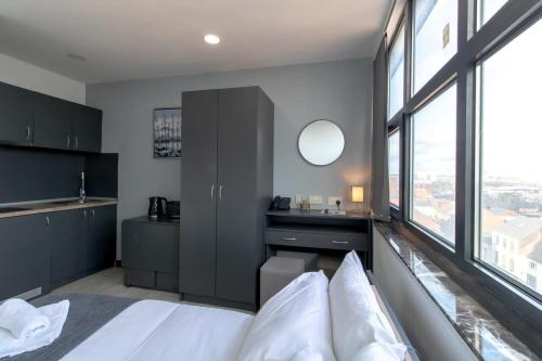 a bedroom with a white bed and a large window at Cosy Budget Sunderland Studio with Great Views in Sunderland