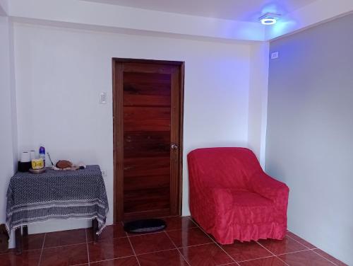 BurgosにあるZia Homestayの赤い椅子とテーブルが備わる客室です。