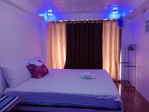 a bedroom with a white bed with blue lights at Zia Homestay in Burgos