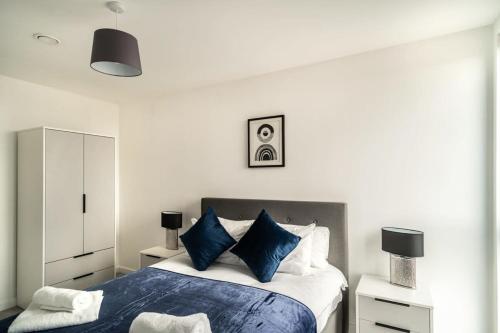 a bedroom with a large bed with blue pillows at Stunning 2 Bedroom Apartment in Central Preston in Preston