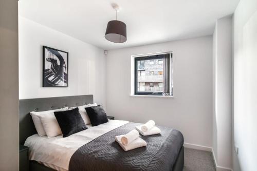 Stunning 2 Bed Apartment in Central Manchester tesisinde bir odada yatak veya yataklar