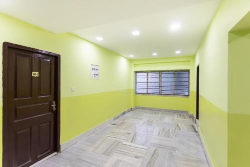 Zimmer mit grünen und gelben Wänden und einer Tür in der Unterkunft OYO Maple The Residence in Thākurdwari
