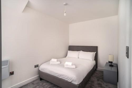 a bedroom with a bed with white sheets and pillows at Spacious 2 Bed Apartment in Waterloo Liverpool in Waterloo