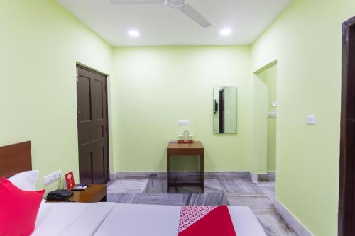 Schlafzimmer mit einem Bett, einem Schreibtisch und einem Spiegel in der Unterkunft OYO Maple The Residence in Thākurdwari