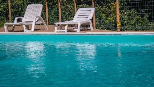 two chairs sitting next to a swimming pool at Residence Panorama in Molina di Ledro