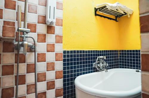鵝鑾的住宿－墾丁迦南美地-海景花園民宿，浴室设有卫生间和黄色及蓝色的墙壁。