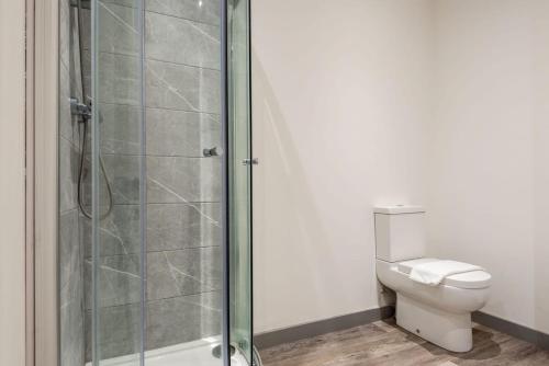 a bathroom with a toilet and a glass shower at Smart 2 Bed Budget Apartment in Central Doncaster in Doncaster