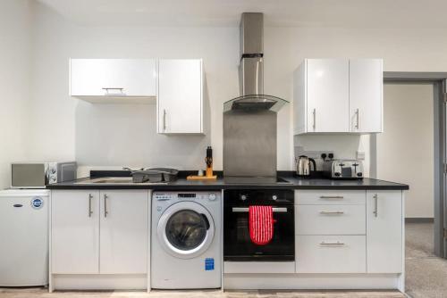 a kitchen with a washing machine and a stove at Smart 2 Bed Budget Apartment in Central Doncaster in Doncaster