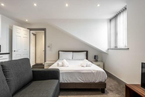 a bedroom with a bed and a couch at Smart Budget Studio Apartment in Central Doncaster in Doncaster